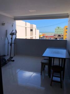 een tafel en een stoel in een kamer met een raam bij Apartamento Piúma in Piúma