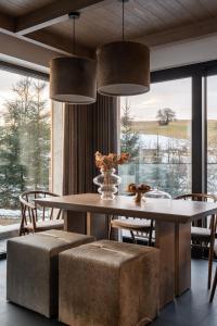 a dining room with a table and chairs and a large window at Luxury Houses Łapsze in Łapsze Niżne