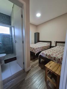 una piccola camera con due letti e un bagno di Refugio 4 suites com ar condicionado e piscina a Águas de Santa Barbara