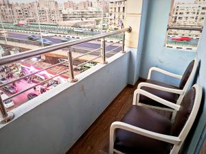 2 stoelen op een balkon met uitzicht op de stad bij Pyrs Giza Heaven in Caïro