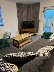 a living room with two couches and a coffee table at Black Dub Cottage in Allonby