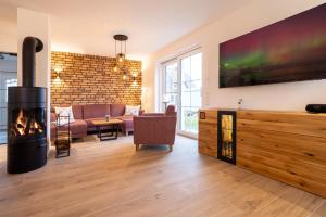 een woonkamer met open haard en een bank bij Reethaus Nordlicht A Top-class in Dranske