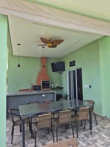 una sala da pranzo con tavolo e ventilatore a soffitto di Refugio 4 suites com ar condicionado e piscina a Águas de Santa Barbara