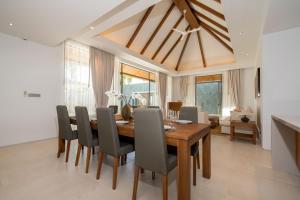 a dining room with a wooden table and chairs at Grand garden villa Free Airport Pickup from 7 days in Phuket