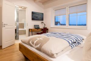 een slaapkamer met een bed, een raam en een bureau bij Reethaus Nordlicht A Top-class in Dranske