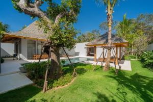 a garden with a swing and a house at Grand garden villa Free Airport Pickup from 7 days in Phuket