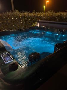 a jacuzzi tub with blue water at night at villetta giulia fronte mare in Stintino