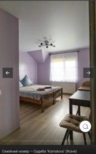 a bedroom with a bed and a window and a chair at Садиба KAMALOVA in Yasinya
