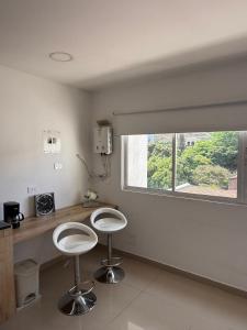 two stools in a kitchen with a counter and a window at Luxury apartment with pool view and Jacuzzi in Cali