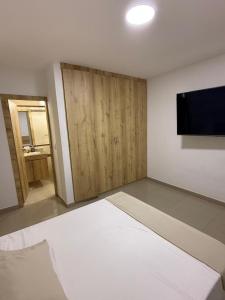 a room with a bed and a flat screen tv at Luxury apartment with pool view and Jacuzzi in Cali