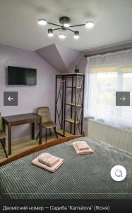 a bedroom with a bed with two towels on it at Садиба KAMALOVA in Yasinya