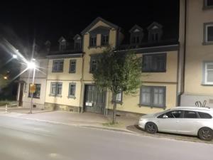 a white car parked in front of a building at night at Ferienwohnung Harald in Gotha