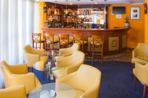 a bar with yellow chairs and a bar counter at L'Opera Hotel in São Paulo