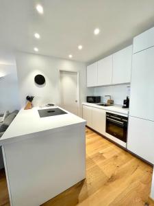 a kitchen with white cabinets and a white counter top at Ferienwohnung "Traumsuite am Tegernsee" in Tegernsee
