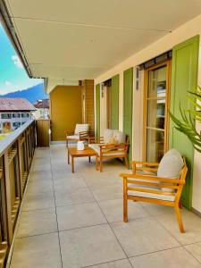 a patio with benches and chairs on a balcony at Ferienwohnung "Traumsuite am Tegernsee" in Tegernsee +12 photos