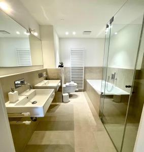 a bathroom with two sinks and a shower at Ferienwohnung "Traumsuite am Tegernsee" in Tegernsee