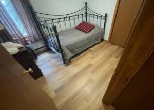 una camera da letto con un letto con un cuscino rosso sopra di Cabin in the pines a Tamworth Altre 2 foto