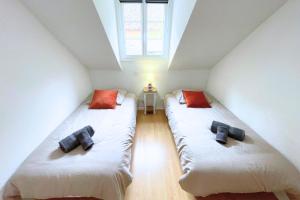two twin beds in a room with a window at Gîte cosy et paisible près de La Mongie in Campan