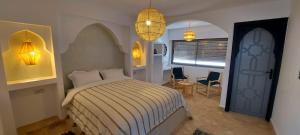 a bedroom with a bed and a table and chairs at Hôtel Riad La Nouvelle Etoile - Agadir in Agadir