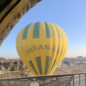 ein gelber Heißluftballon steht unter einer Brücke in der Unterkunft King House in Luxor