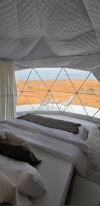 a bedroom with two beds with a view of the desert at The mirage dome in Badīyah