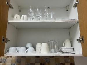 a cupboard with plates and wine glasses and dishes at At your home in Conakry in Conakry
