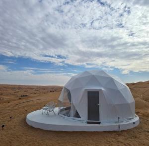 a white tent in the middle of the desert at The mirage dome in Badīyah