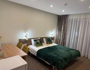 una stanza d'albergo con un letto e un tavolo di Simona House a Šiauliai