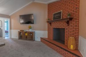 een woonkamer met een stenen open haard en een tv bij Legoland Escape in Winter Haven