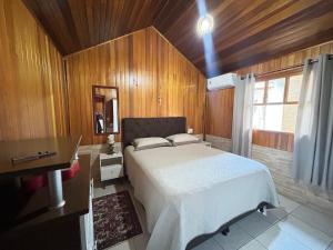 een slaapkamer met een bed in een houten kamer bij Lagoa Country Club in Cidreira +97 foto's