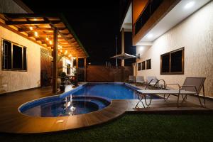 a swimming pool with a table and chairs in a building at Cherry Signature Condos in Adentan