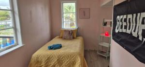 a small bedroom with a bed with a yellow blanket at Hidden gem cheap and affordable in Te Kopuru