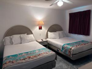 twee bedden in een hotelkamer met twee bij Apollo Motel in Wildwood Crest +63 foto's