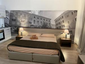 a bedroom with a large bed with a painting on the wall at ROCKEFELLER SUIT Apartment in Sassari