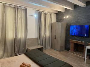 a living room with a bed and a flat screen tv at ROCKEFELLER SUIT Apartment in Sassari