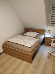 a bed with a wooden frame in a room at FW zur Gemütlichkeit in Hirschaid