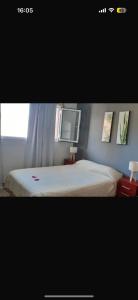 a picture of a bedroom with a bed and a window at Departamentos Necochea in Necochea