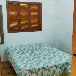 a bed in a room with a window at Casa para até 6 pessoas, próxima do mar in Cidreira