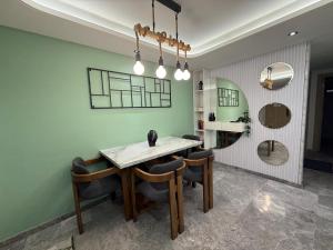 a dining room with a table and some chairs at Hilton View Tower Residency Apartment Tanger Partial Sea View in Tangier
