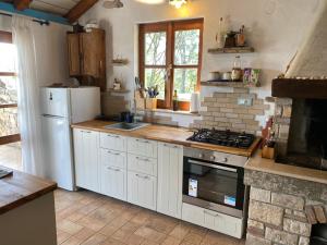 a kitchen with a white refrigerator and a stove at Girica in Ugrinići