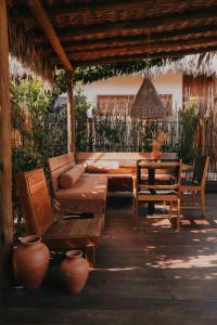 a patio with a couch and a table and chairs at Pousada Buriti Atins Private in Atins