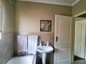 a bathroom with a sink and a bath tub and a white sink at Blissfulnest stay two in Roodepoort +14 photos