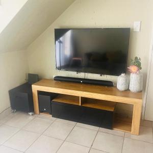 a flat screen tv sitting on top of a wooden table at Blissfulnest stay two in Roodepoort