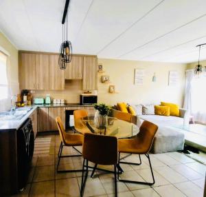 a kitchen and a living room with a table and chairs at Blissfulnest stay two in Roodepoort