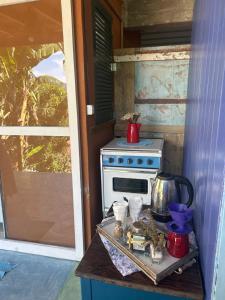 una cucina con una stufa e una teiera su un tavolo di Chalé Vista Mar a Ilhabela
