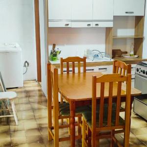 a kitchen with a wooden table and chairs at Casa para até 6 pessoas, próxima do mar in Cidreira