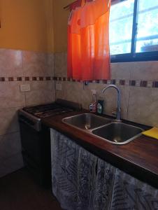 a kitchen counter with a sink and a stove at Monoambiente in Mar de Ajó