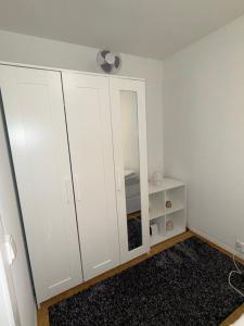 a bedroom with white cabinets and a mirror at Modern Oslo Studio Near Aker Brygge in Oslo