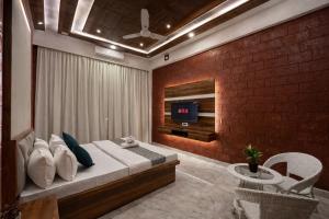 a bedroom with a bed and a brick wall at Selborne Villas in Nagothna +58 photos