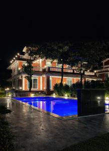 a swimming pool in front of a building at night at Selborne Villas in Nagothna